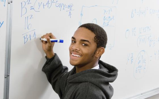 male student at whiteboard with math problems