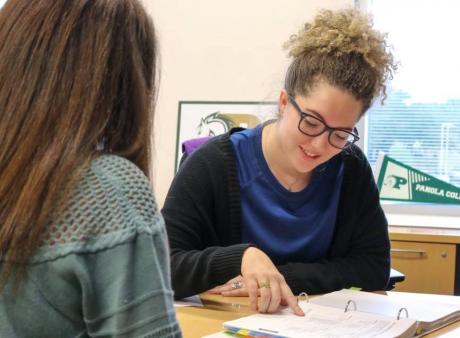 advisor with student looking at documents