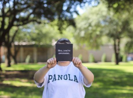 student in panola shirt hols sign that say you're awesome