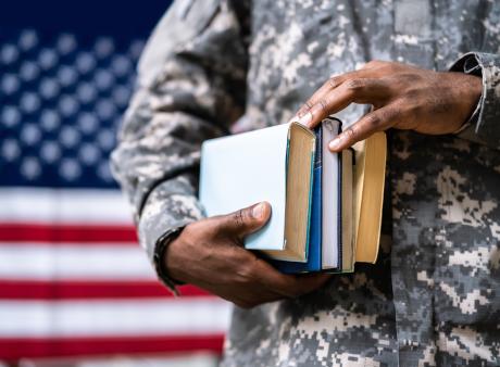 Military person holding books