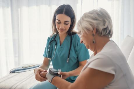 female CNA taking woman's vitals