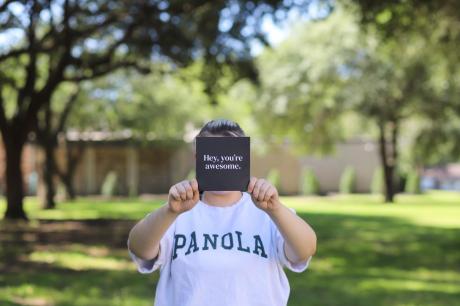 student in panola shirt hols sign that say you're awesome