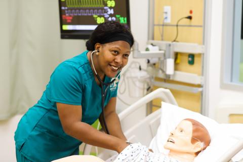 female ADN student in sim lab