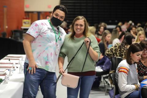 Attendee and volunteer pose with purse
