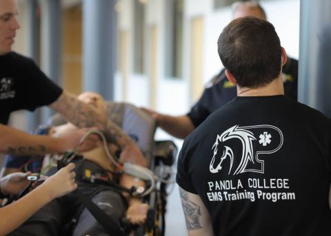 EMT Student overlooks others as they work on CPR mannequien