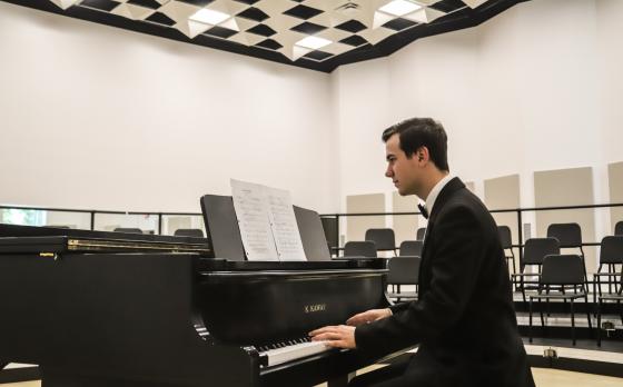 male student plays piano