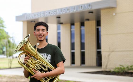 male student holding instrument